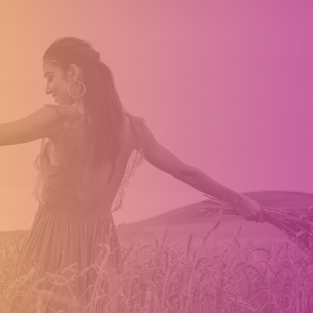 Woman dancing in a field holding a bouquet - Mastering Alchemy